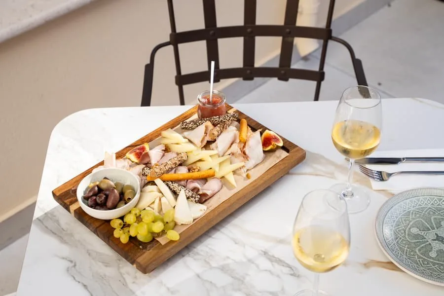 A cheese board and white wine